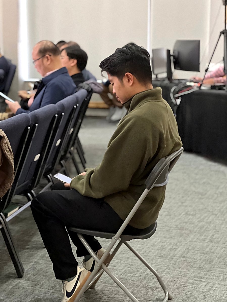 A churchgoer following along in the Bible on his phone during the service