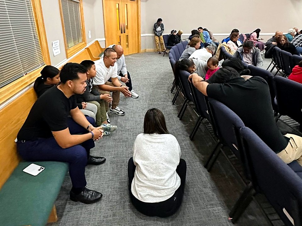 Church members praying together in small groups in the sanctuary