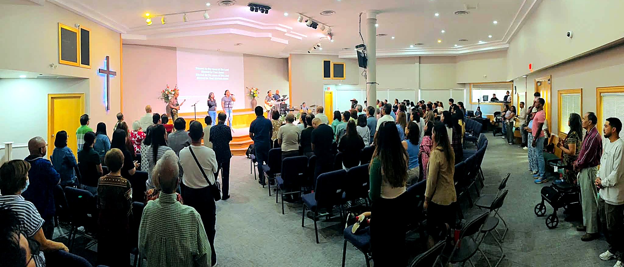 The MFBC congregation standing in worship during a Sunday service